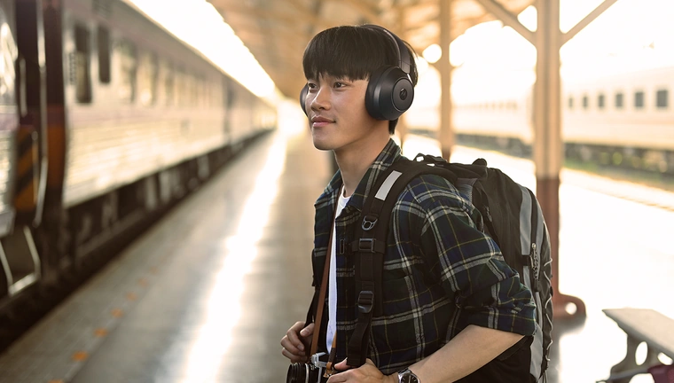 Путешественник в наушниках Motorola MOTO XT800 ANC на железнодорожной станции