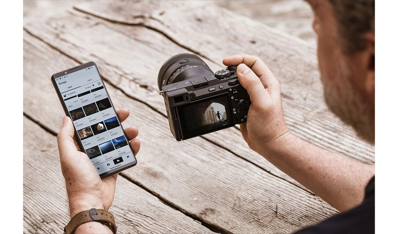 Изображение пользователя, переносящего изображения с камеры на смартфон