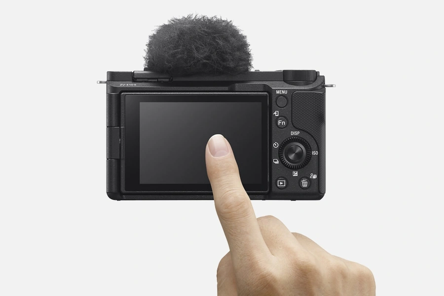 Палець, що торкається LCD-монітора на задній панелі камери