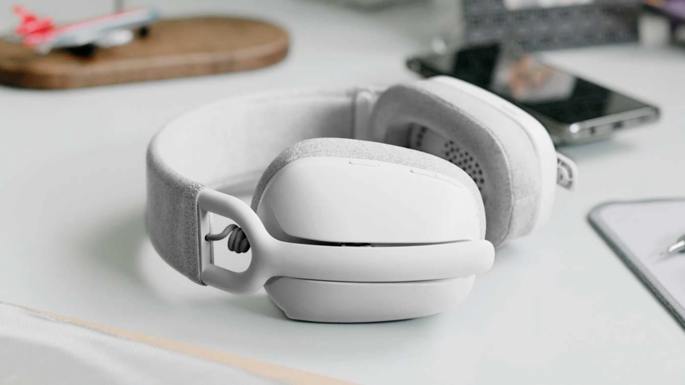 Навушники Logitech Zone Vibe 100 на столі поруч зі смартфоном