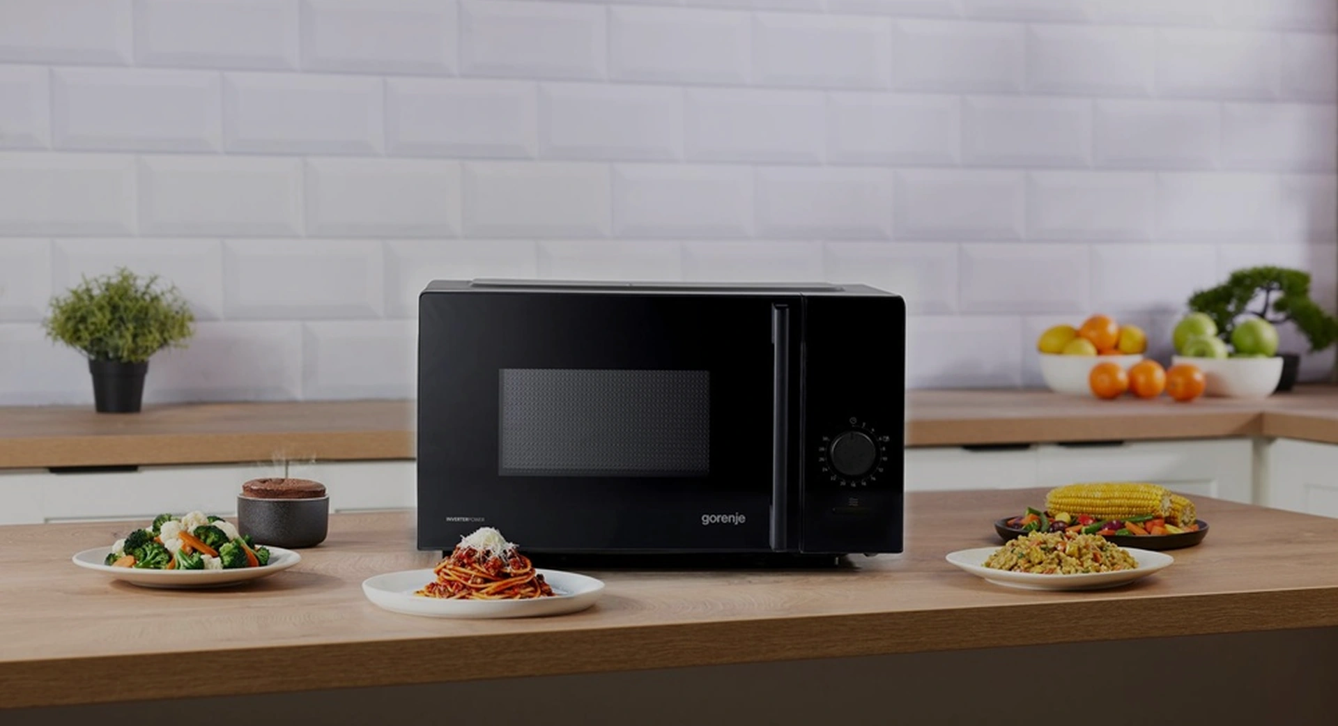 Чёрная микроволновая печь Gorenje MO20E1B15 на кухонной столешнице