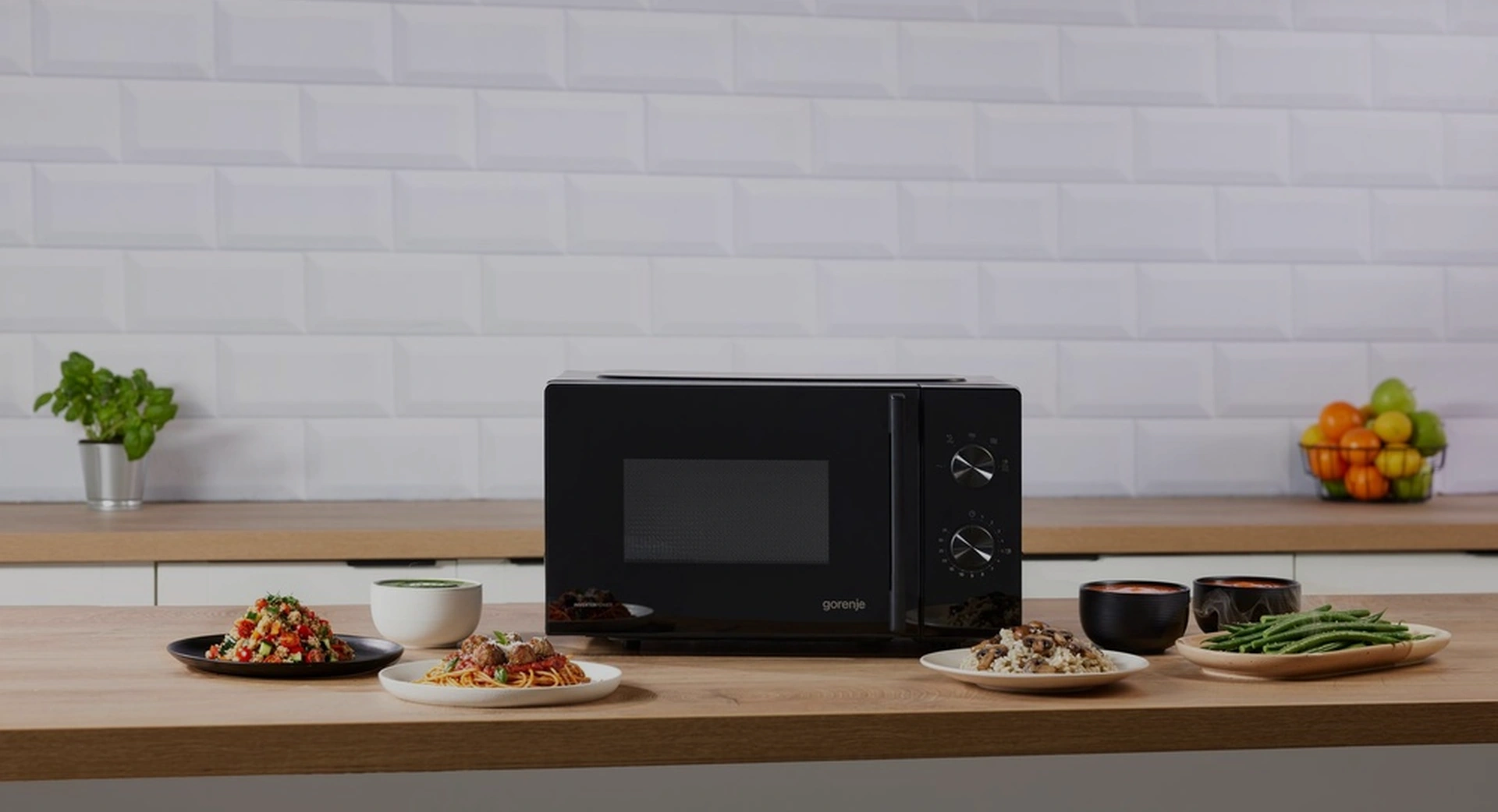 Чёрная микроволновая печь Gorenje MO20E1B5 на кухонной столешнице