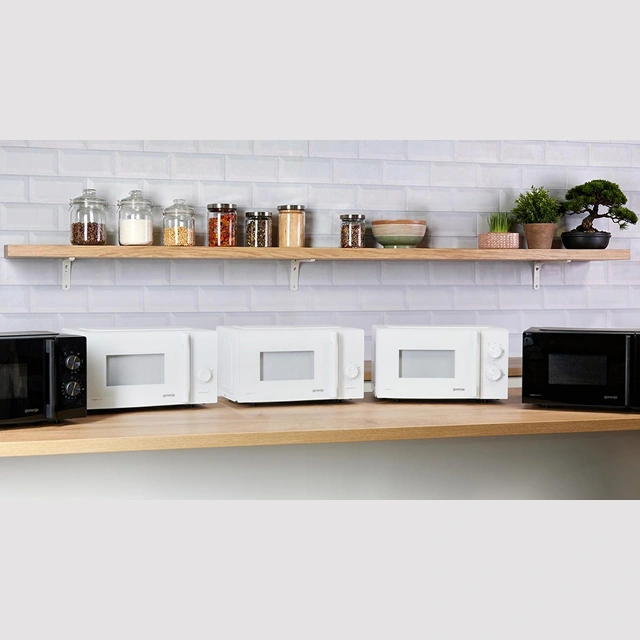 Чёрная и белая микроволновые печи Gorenje на кухонной полке