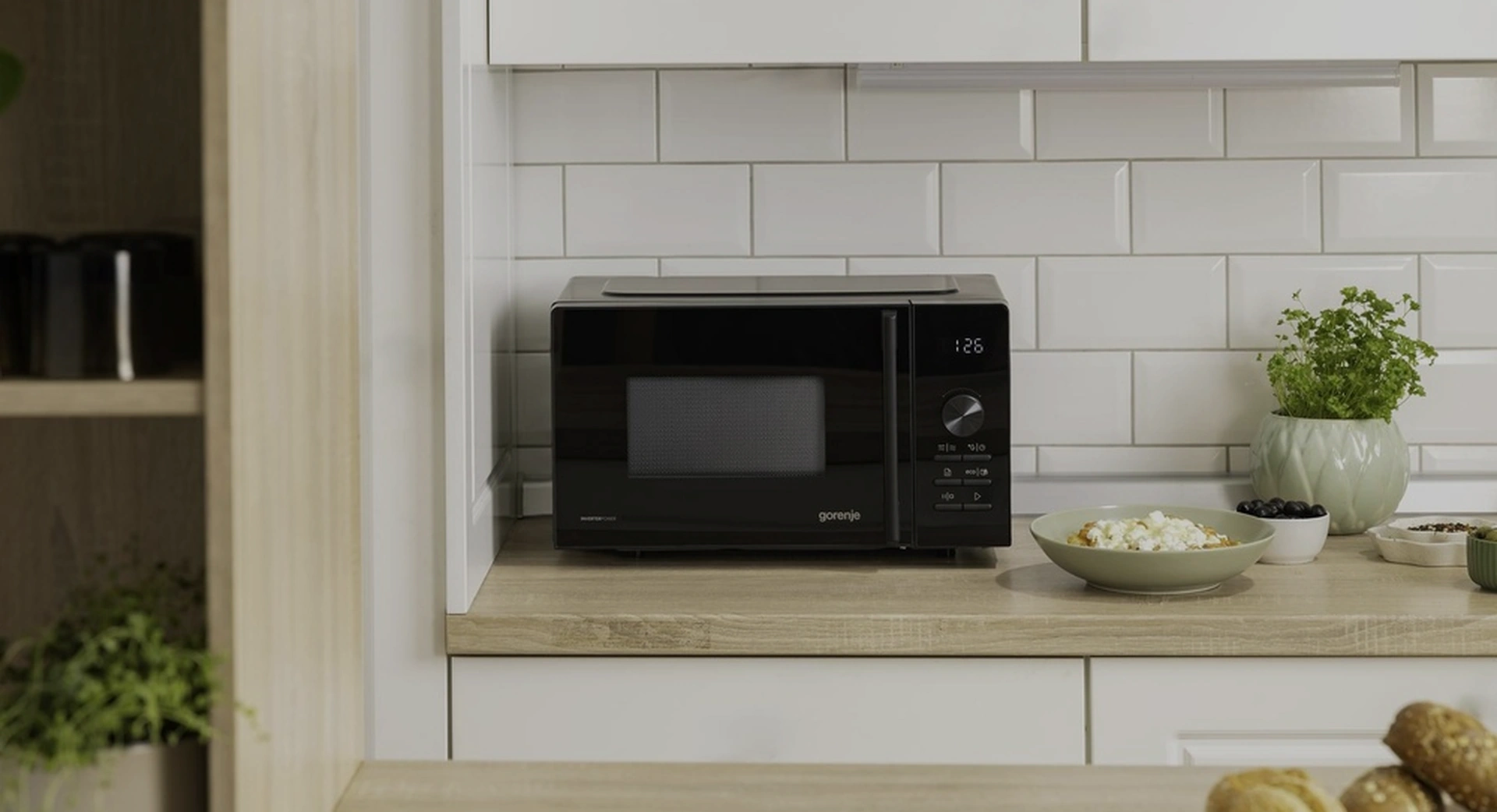 Чёрная микроволновая печь Gorenje MO20A4B5 на кухонной столешнице