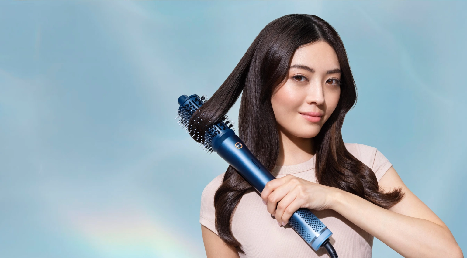 Женщина укладывает волосы мультистайлером Philips Aqua SenseIQ