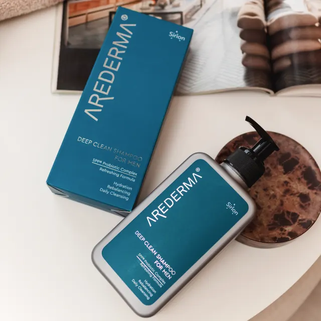 Два флакони чоловічого шампуню AREDERMA Deep Clean на кам'яній текстурованій поверхні