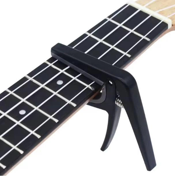 Каподастр CAPO для укулеле (пластик) Черный + Медиатор - Фото 1 Каподастр CAPO для укулеле (пластик) Черный + Медиатор - изображение 1