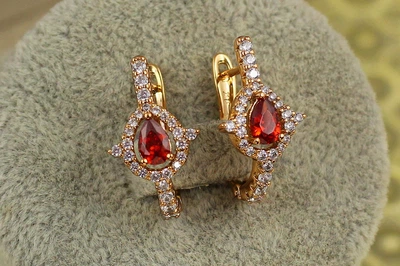 Сережки Xuping Jewelry Капелька з червоним каменем в обідку з шипами 2 см золотисті