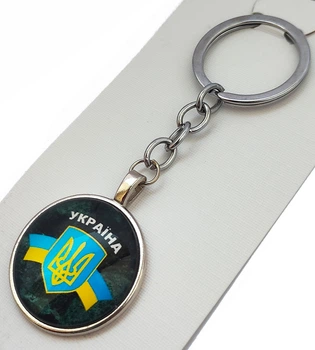 Патріотичний брелок з гербом України та синьо-жовтою стрічкою на темному фоні