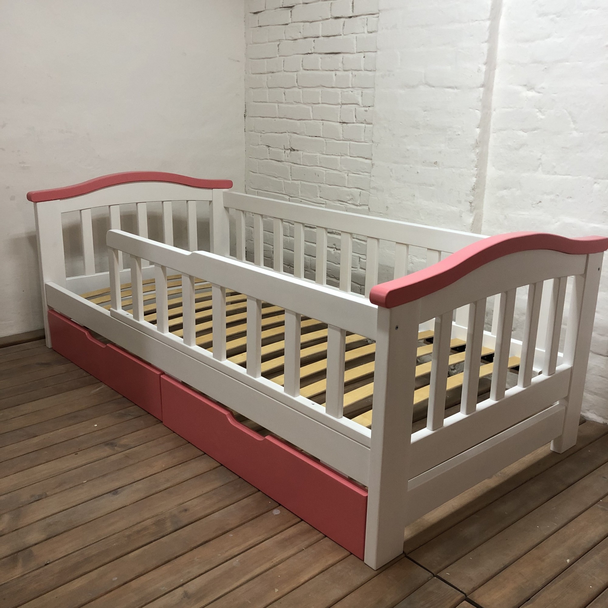 

Детская кроватка WoodHouse 1600х800 с ящиками, защитным бортиком и перилом белая+розовый натуральное дерево